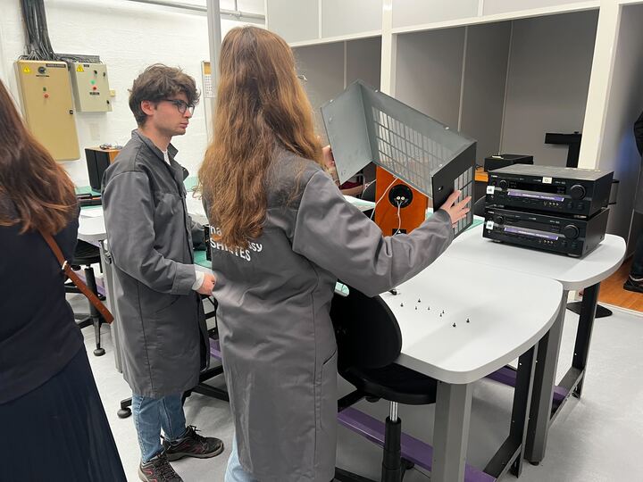 Deux élèves en blouse grise d'atelier manipulent du matériel électronique et des boîtiers sur une table de laboratoire au Lycée Bernard Palissy de Saintes.